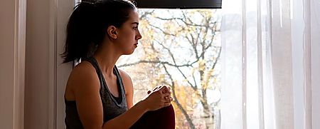 Woman sitting by a window, looking outside